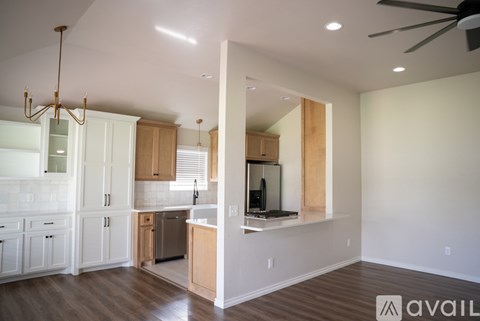 A modern kitchen with white cabinets and a wooden island.
