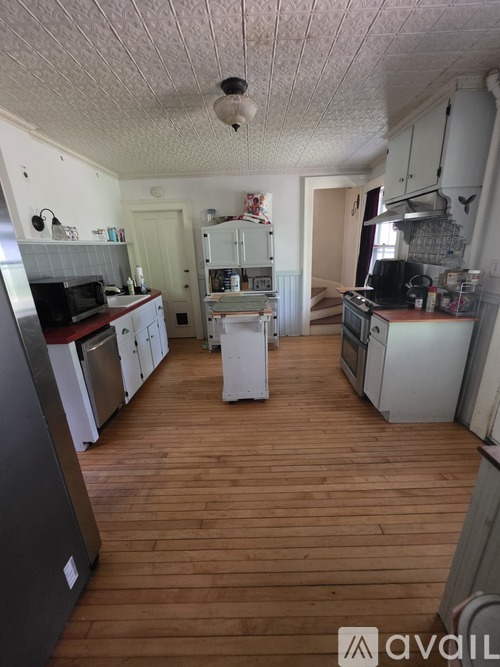 A kitchen with wooden floors and white appliances.