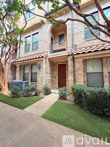 A brick house with a brown door and windows.