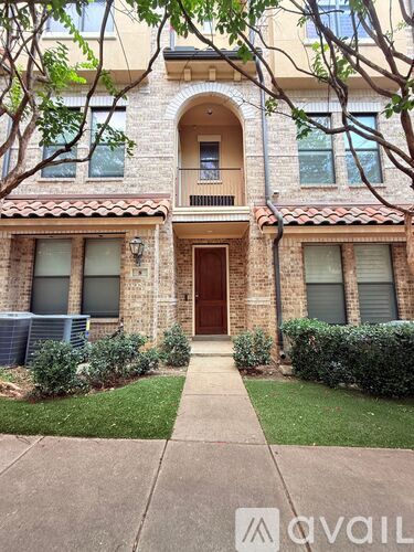 A building with a brown door and windows with trees in front.