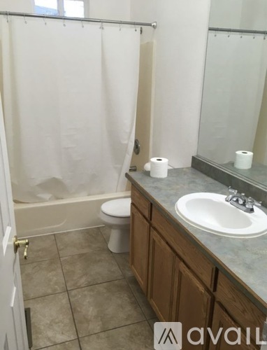 A bathroom with a toilet, sink, and shower.