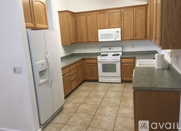 A kitchen with wooden cabinets and a white refrigerator.