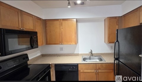 A kitchen with black appliances and wooden cabinets.
