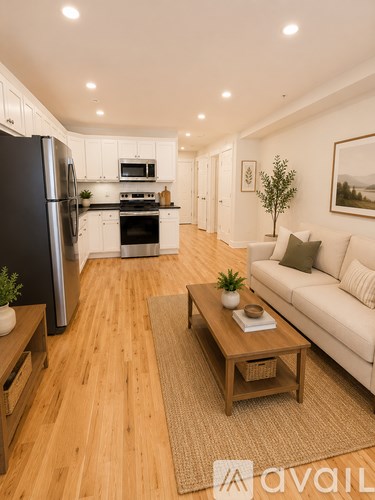 A modern kitchen with a black refrigerator and white cabinets.