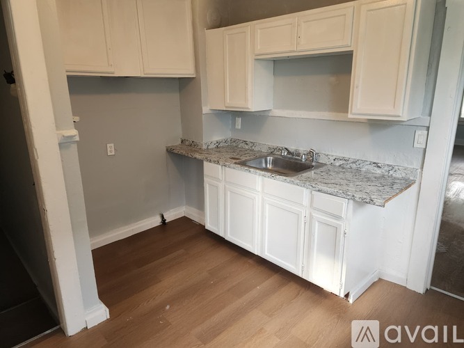 A kitchen with white cabinets and a granite countertop.