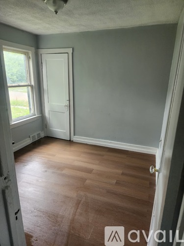 A room with a wooden floor and a white door.