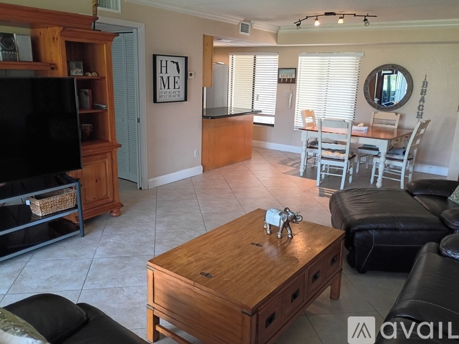 A living room with a wooden coffee table and a flat screen TV.