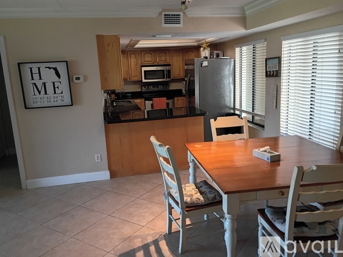 A kitchen with a table and chairs in front of it.