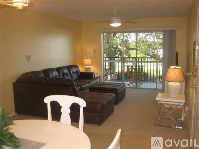 A living room with a white table and a black leather couch.