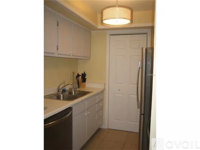 A kitchen with white cabinets and a white door.