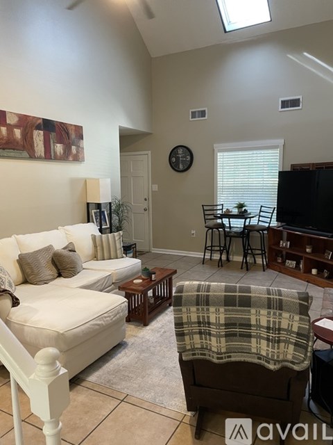A living room with a couch, chair, and a television.