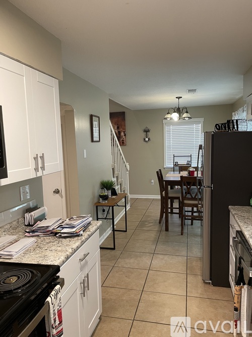 A kitchen with white cabinets and a black stove top oven.