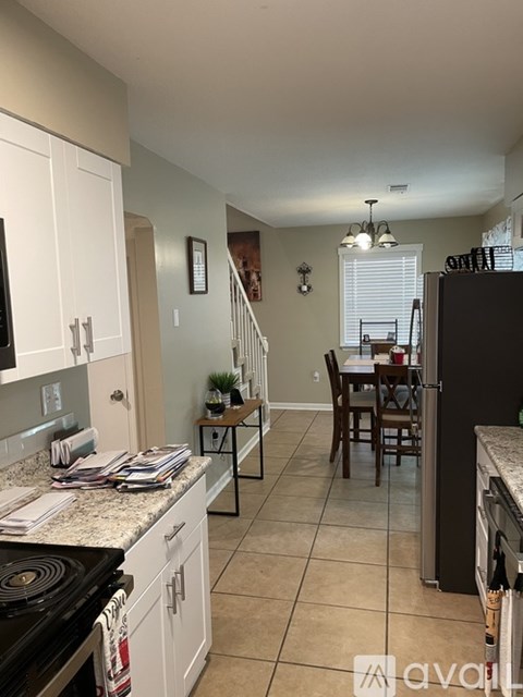 A kitchen with white cabinets and a black stove top oven.