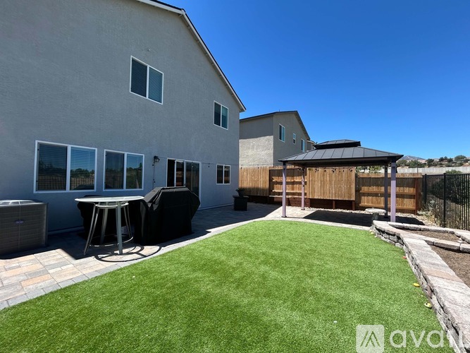 A house with a backyard featuring a patio and a hot tub.
