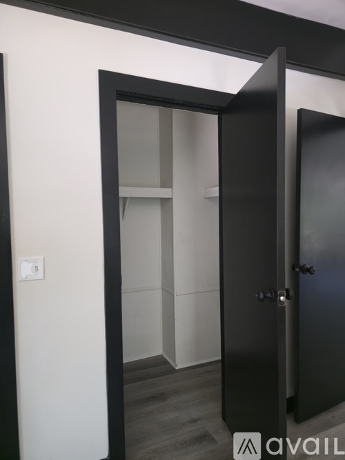 A black door with a glass window is open.
