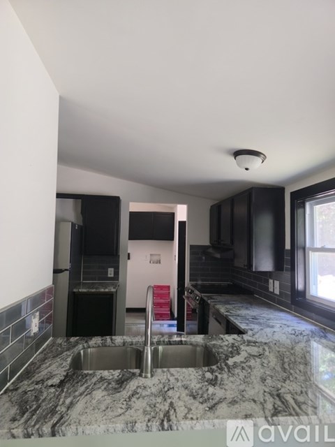 A kitchen with a marble counter top and a sink.