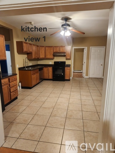 A kitchen with a tile floor and a ceiling fan.