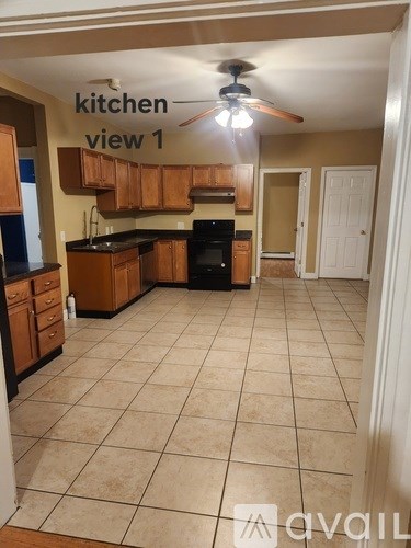 A kitchen with a tile floor and a ceiling fan.