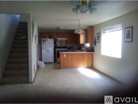 A kitchen with a refrigerator, stove, and cabinets.