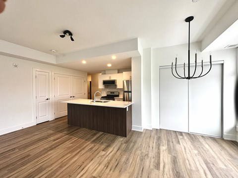 A kitchen with a wooden floor and white walls.