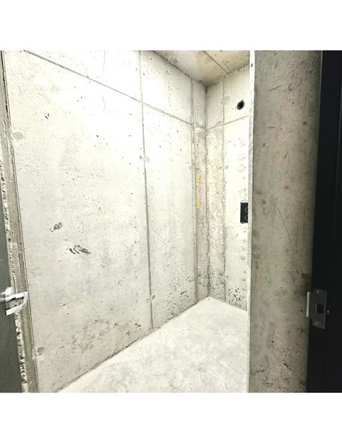 A dirty, unfinished bathroom with a shower stall.