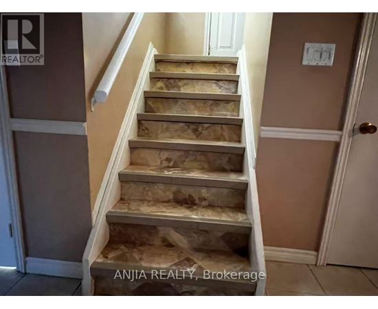 A set of stairs with a beige carpeted runner.