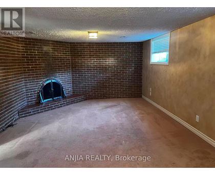 A room with a brick wall and a fireplace.