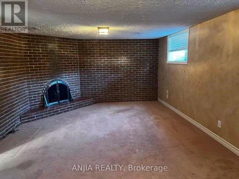 A room with a brick wall and a fireplace.