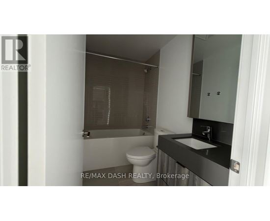 A bathroom with a toilet, sink and shower.