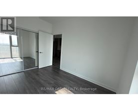 A room with a door and a window with a view of a building outside.