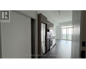 A modern kitchen with a refrigerator, oven, and sink.