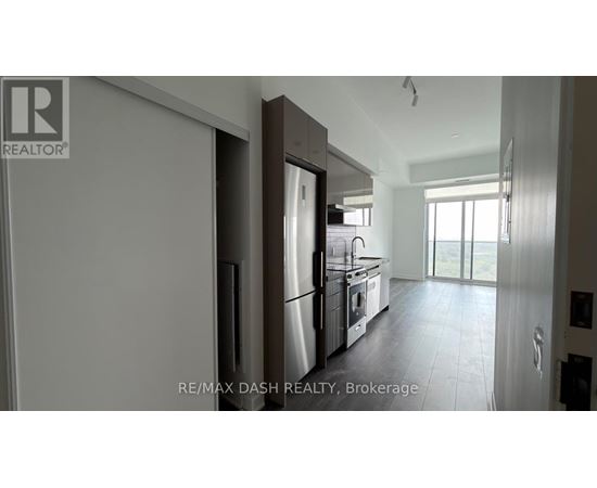 A modern kitchen with a refrigerator, oven, and sink.