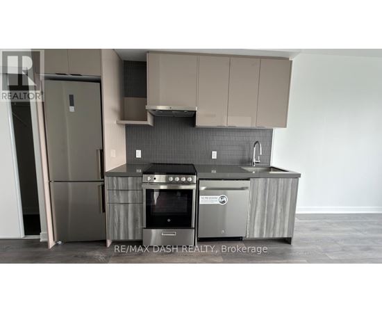 A modern kitchen with a stainless steel refrigerator and oven.