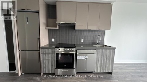 A modern kitchen with a stainless steel refrigerator and oven.