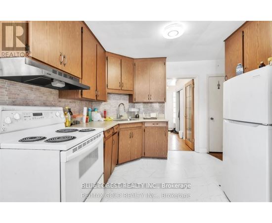 A kitchen with white appliances and wooden cabinets.