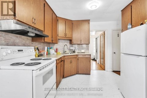 A kitchen with white appliances and wooden cabinets.