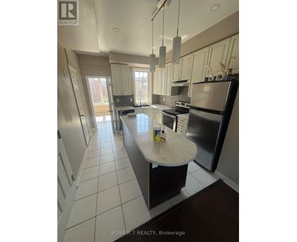 A kitchen with a black refrigerator and a white countertop.