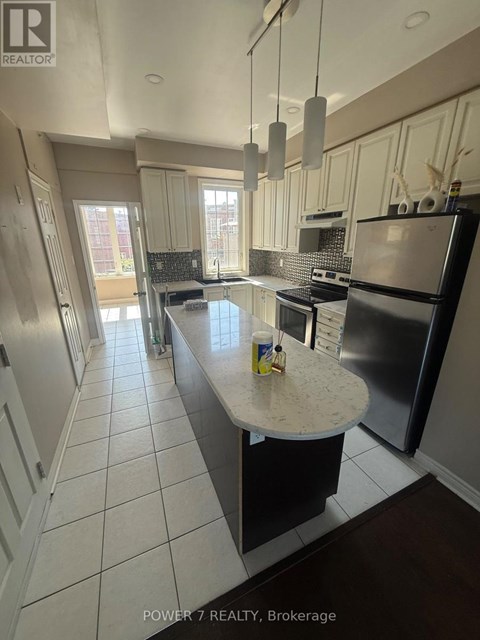 A kitchen with a black refrigerator and a white countertop.