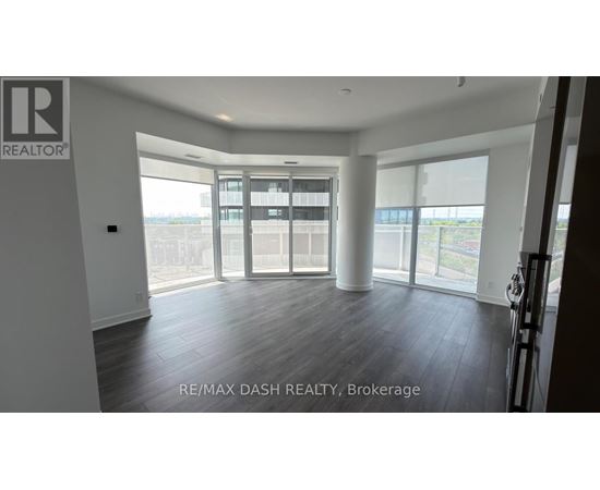 A spacious room with a large window and sliding glass doors.