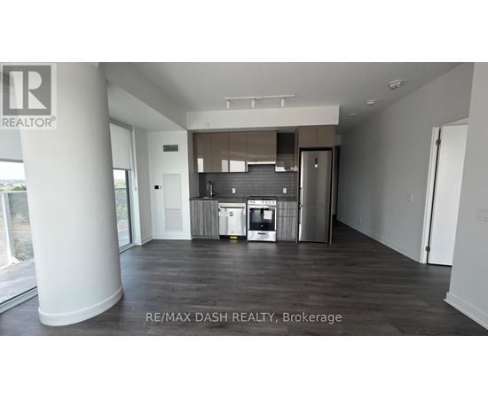 A spacious room with a kitchenette and a refrigerator.