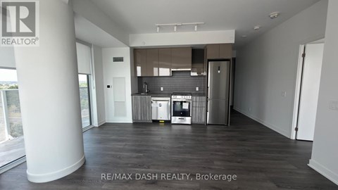 A spacious room with a kitchenette and a refrigerator.