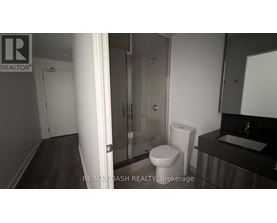 A bathroom with a toilet, sink, and shower.
