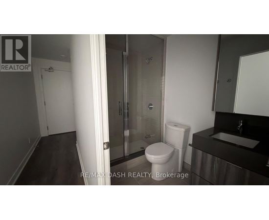 A bathroom with a toilet, sink, and shower.