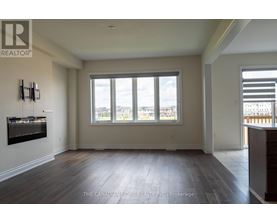 A spacious room with a large window and wooden flooring.