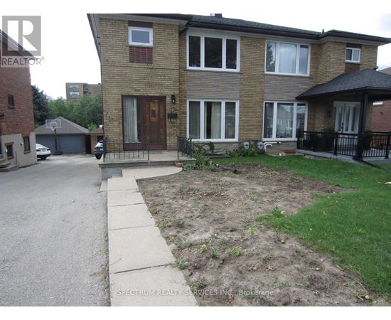 A brick house with a brown door and a small front yard.