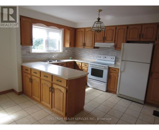 A kitchen with wooden cabinets and a white refrigerator.