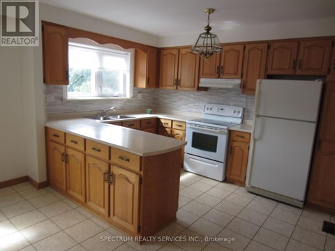 A kitchen with wooden cabinets and a white refrigerator.