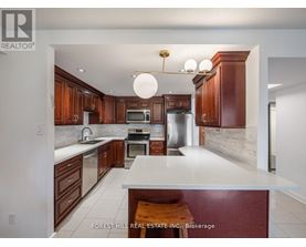 A kitchen with wooden cabinets and a white island.