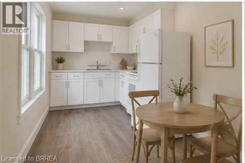 A kitchen with white cabinets and a wooden table.
