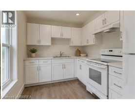 A kitchen with white cabinets and appliances.